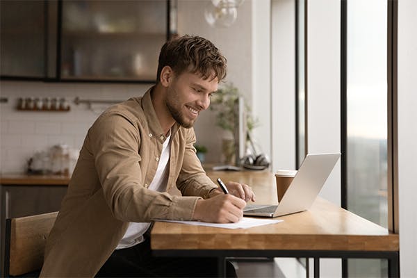 Close-up-smiling-young-man-using-laptop